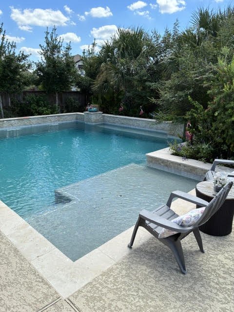 Clear water in a rectangular pool with a sun shelf after cleaning