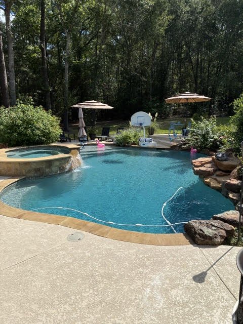 Freeform pool with a spillover spa and rock edging