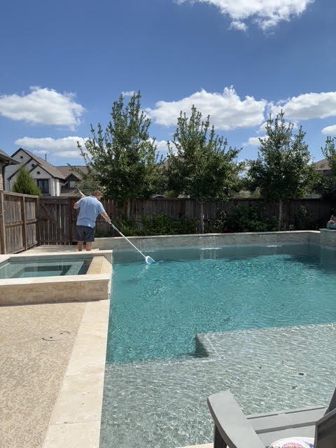 Skimming the surface of a rectangular pool during a cleaning visit